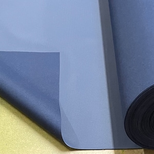 May include: A roll of dark blue fabric with a lighter blue backing. The fabric is rolled up and the end is folded over.
