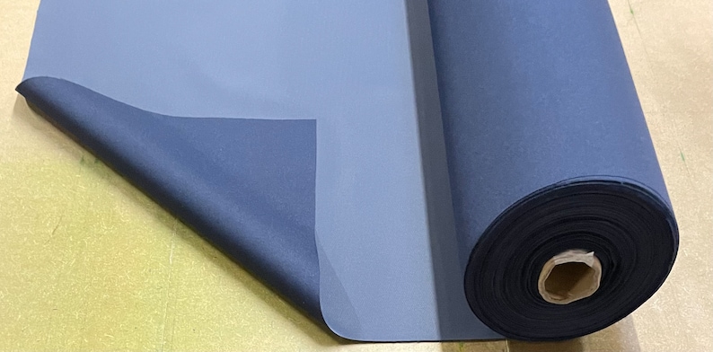 May include: A roll of dark blue fabric with a lighter blue backing. The fabric is rolled up and the end is folded over.