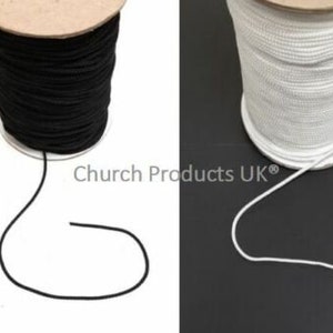May include: Two spools of elastic cord, one black and one white. The cord is wound around the spools and is ready to be used for crafts or sewing projects.