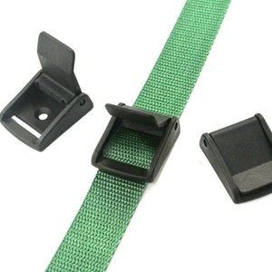 May include: Three black plastic slide buckles for a green nylon strap. The buckles are designed to be used with a strap that is 2.5 cm wide.