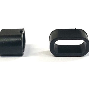 May include: Two black plastic cord end stoppers. One is a solid rectangle shape, the other is a rectangle with an oval opening.