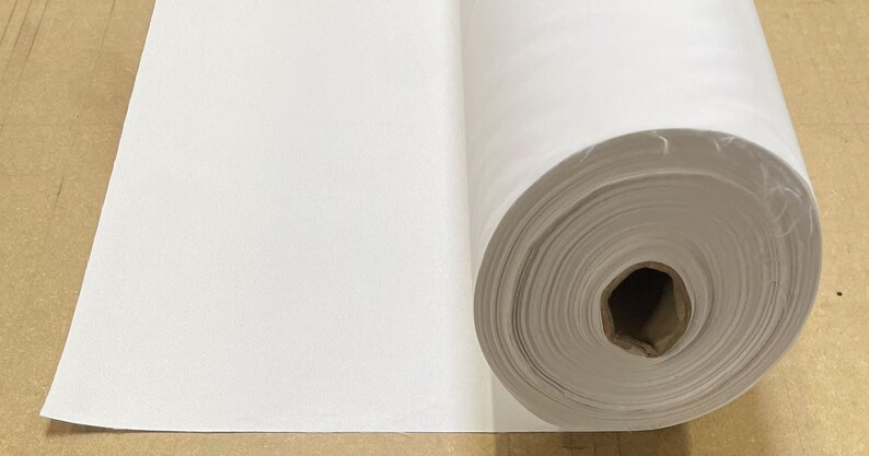 May include: A white roll of fabric, unfurled to show the texture of the material.