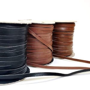 May include: Three spools of leather cord in black, brown, and tan. The cords are wound around cardboard spools.