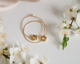 Pendientes de aro minimalistas en oro con dije de flor