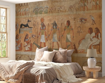 May include: A bedroom with a large wall mural depicting ancient Egyptian hieroglyphics and figures. The mural features a scene of gods, animals, and people. The room is decorated in a bohemian style with a bed, throw blankets, and a side table with a lamp.