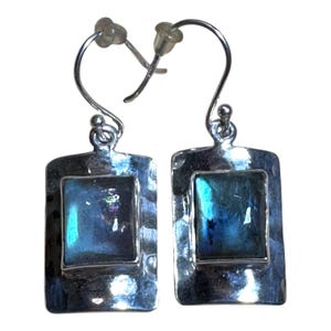 May include: Silver dangle earrings with a rectangular blue iridescent gemstone set in a hammered silver frame.