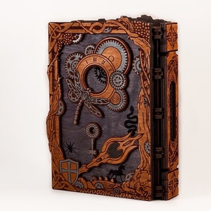 May include: A wooden journal with a steampunk design. The cover features a dragonfly, gears, and a keyhole. The journal is bound with a dark brown leather spine.