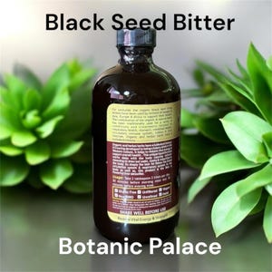 K&ouml;nnte beinhalten: Eine dunkelbraune Glasflasche mit einem schwarzen Etikett, auf dem "Black Seed Bitter" steht und Informationen &uuml;ber die Inhaltsstoffe, die Anwendung und die Vorteile des Produkts enthalten sind. Die Flasche ist als glutenfrei, ungefiltert, vegan, nicht-GVO und halal gekennzeichnet. Das Etikett weist auch darauf hin, dass die Flasche "Vor Gebrauch gut sch&uuml;tteln" und "Vitalit&auml;t und Kraft wiederherstellen" soll. Die Flasche steht auf einer gr&uuml;nen Oberfl&auml;che.