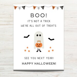 K&ouml;nnte beinhalten: Ein wei&szlig;es Schild mit schwarzem Text, auf dem steht "BOO! Es ist kein Trick. Wir haben keine S&uuml;&szlig;igkeiten mehr. Bis n&auml;chstes Jahr! Frohes Halloween!" Ein Cartoon-Geist mit einem K&uuml;rbis-Eimer befindet sich in der Mitte des Schildes.