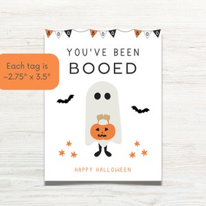 Puede incluir: Un fantasma blanco sosteniendo una calabaza con el texto "You've Been Booed" y "Happy Halloween" sobre un fondo blanco. Cada etiqueta mide aproximadamente 7 cm por 9 cm.
