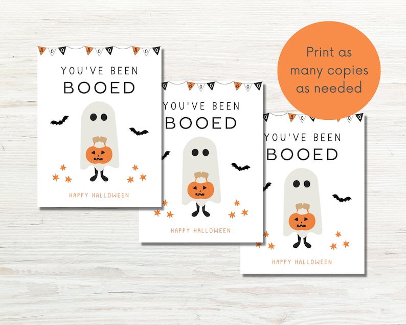 Puede incluir: Tres tarjetas imprimibles con un fantasma sosteniendo una calabaza y el texto "You've Been Booed" y "Happy Halloween".