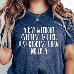 May include: A navy blue t-shirt with the text "A day without knitting is like... Just kidding I have no idea" in white.