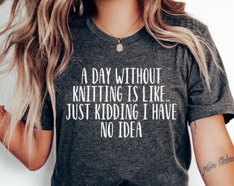 May include: A dark gray t-shirt with white text that reads "A day without knitting is like... Just kidding I have no idea".