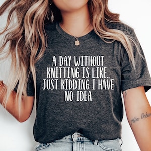 May include: A dark gray t-shirt with white text that reads "A day without knitting is like... Just kidding I have no idea".