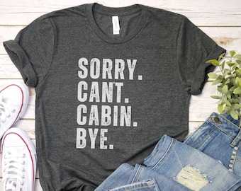 May include: A dark gray t-shirt with the text "SORRY. CANT. CABIN. BYE." printed in white.