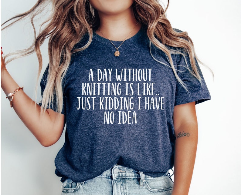 May include: A navy blue t-shirt with the text "A day without knitting is like... Just kidding I have no idea" in white.