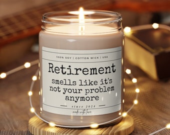 May include: A brown soy candle with a white label that reads "Retirement smells like it's not your problem anymore since 2024 made with love".