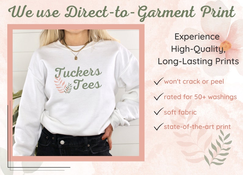 May include: White sweatshirt with the text "Tuckers Tees" and a green leaf design. The text "We use Direct-to-Garment Print" is at the top of the image. The text "Experience High-Quality, Long-Lasting Prints" is on the right side of the image. Below the text are four check marks with the following text: "won't crack or peel", "rated for 50+ washings", "soft fabric", and "state-of-the-art print".