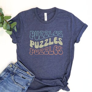 a t - shirt that says puzzles and a pair of jeans