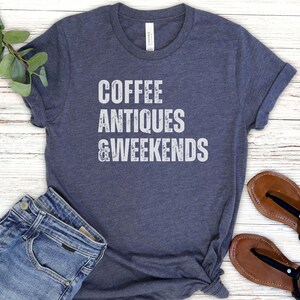 a t - shirt that says coffee antiques and weekends next to a pair of