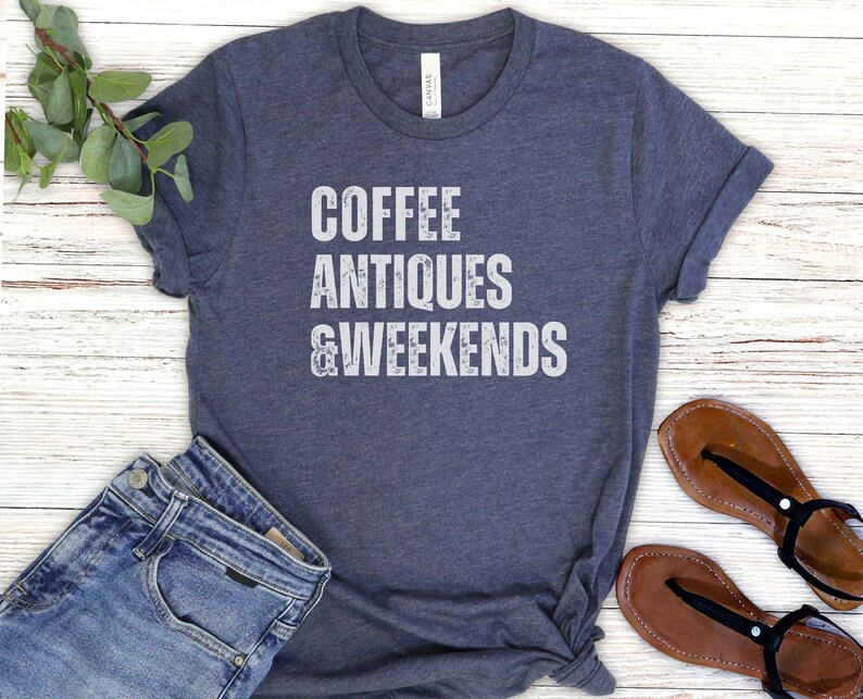 a t - shirt that says coffee antiques and weekends next to a pair of