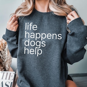 May include: A dark gray sweatshirt with the text "life happens dogs help" printed in white.