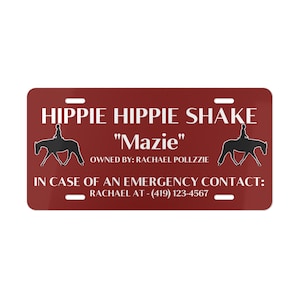 May include: A red personalized horse license plate with the text "HIPPIE HIPPIE SHAKE" and "Mazie" in white. The text "OWNED BY: RACHAEL POLLZZIE" and "IN CASE OF AN EMERGENCY CONTACT: RACHAEL AT - (419) 123-4567" is also included in white.