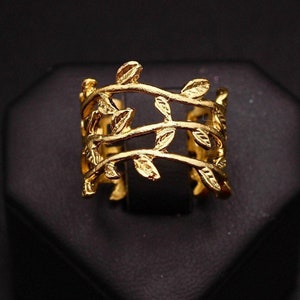 May include: A gold-toned ring with a delicate design of intertwining branches and leaves.