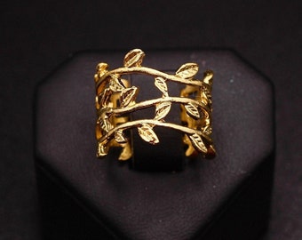 May include: A gold-toned ring with a delicate design of intertwining branches and leaves.