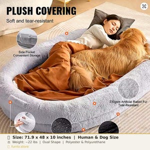 May include: A large, oval-shaped gray plush pet bed measuring 71.9 by 48 by 10 inches. The bed features a soft, tear-resistant artificial rabbit fur surface, a side storage pocket, and a non-slip base with a black dotted texture for stability.