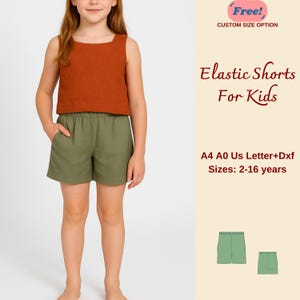 Puede incluir: Una niña lleva un top sin mangas de color óxido con cuello cuadrado y pantalones cortos elásticos verde oliva. La imagen incluye el texto "Elastic Shorts For Kids" y "Tallas: 2-16 años".