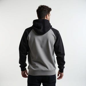 May include: A gray and black hooded sweatshirt with a raglan sleeve design. The sweatshirt has a drawstring hood and a kangaroo pocket.
