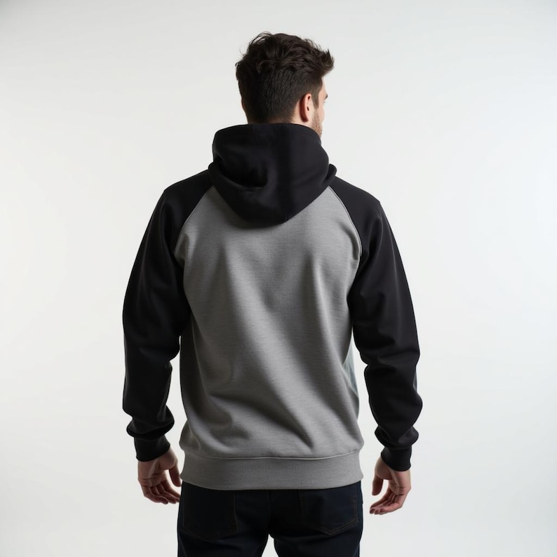 May include: A gray and black hooded sweatshirt with a raglan sleeve design. The sweatshirt has a drawstring hood and a kangaroo pocket.