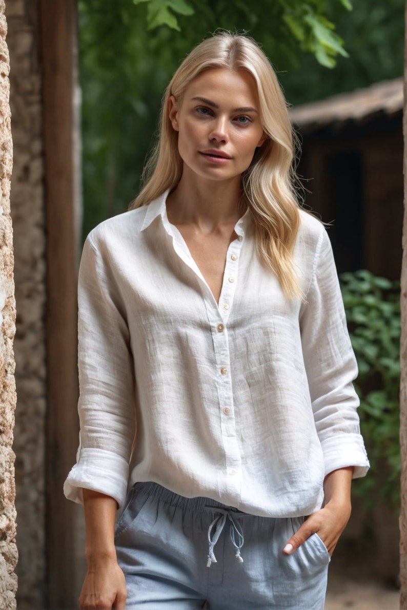Puede incluir: Una mujer con una camisa blanca de lino con botones y mangas largas y un pantal&oacute;n azul claro.
