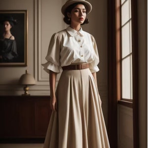 May include: A woman wearing a white button-down shirt with puffed sleeves, a brown belt, and a beige skirt. She is wearing a beige hat and has her hair pulled back.