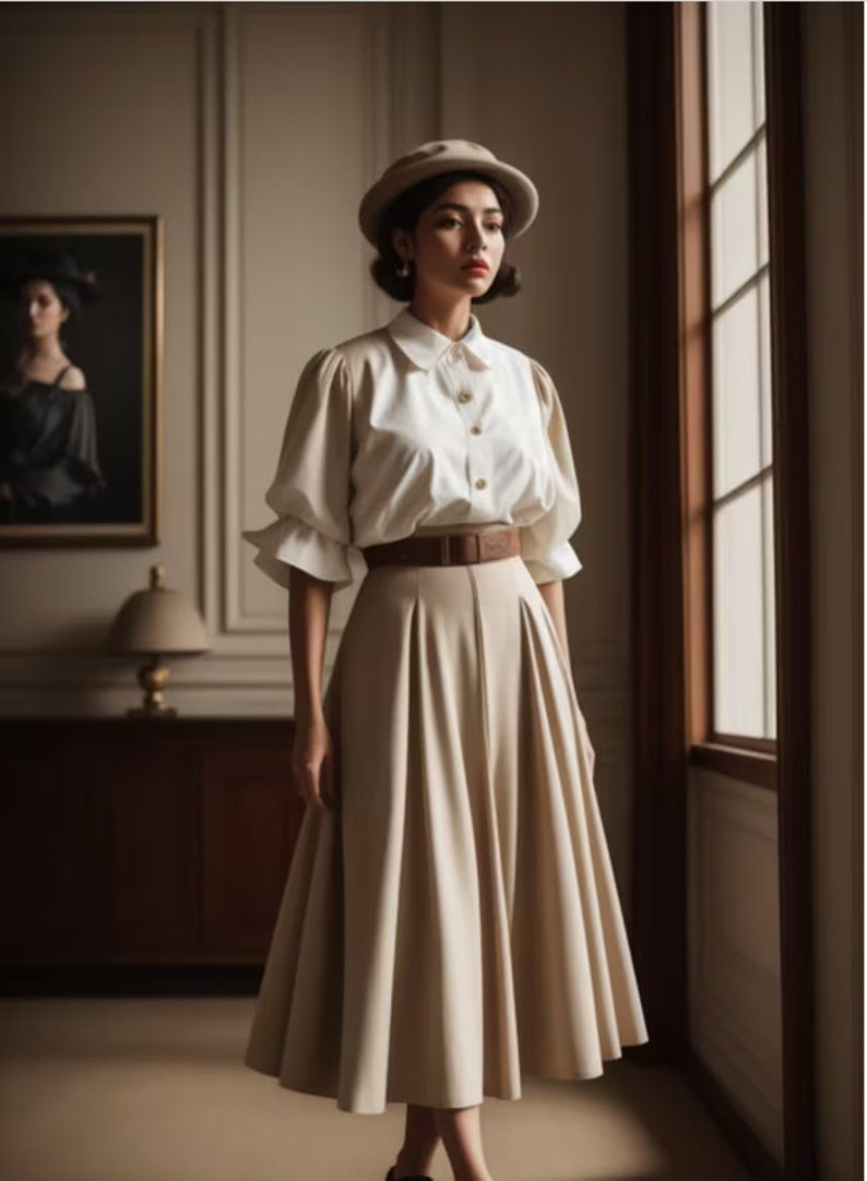 May include: A woman wearing a white button-down shirt with puffed sleeves, a brown belt, and a beige skirt. She is wearing a beige hat and has her hair pulled back.