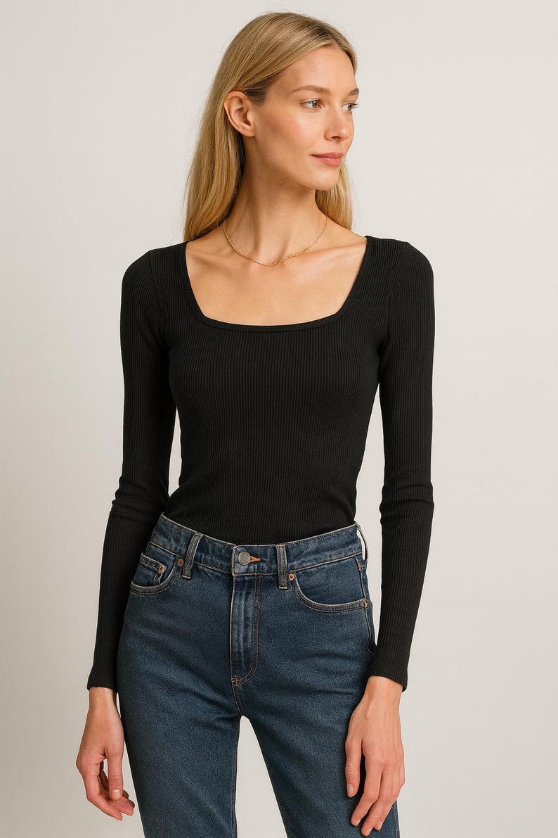 May include: A black long-sleeve top with a square neckline and ribbed texture. The top is paired with blue denim jeans. The model is wearing a gold necklace.