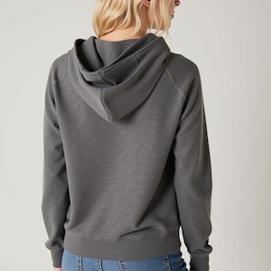 May include: A gray hooded sweatshirt with a relaxed fit. The sweatshirt has a drawstring hood and long sleeves.