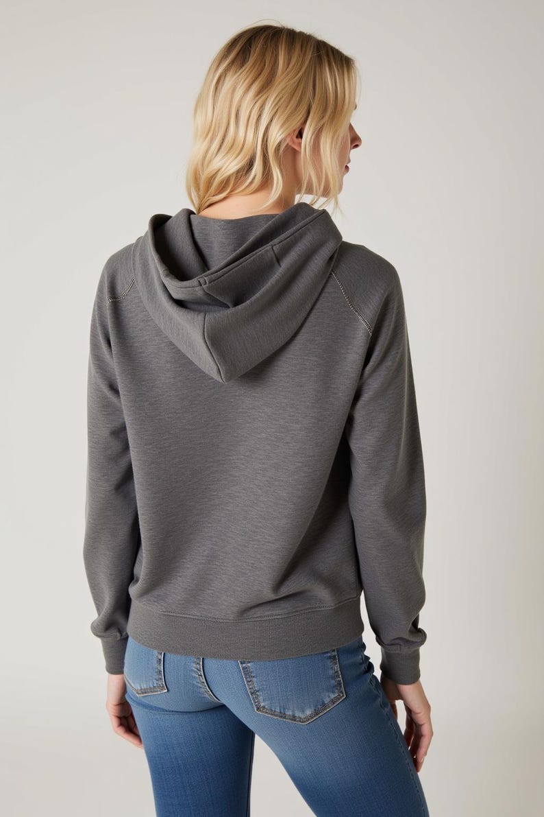 May include: A gray hooded sweatshirt with a relaxed fit. The sweatshirt has a drawstring hood and long sleeves.
