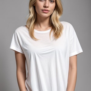 以下が含まれることがあります： ゆったりとしたフィットの白い半袖クルーネックTシャツ。シャツは柔らかく軽量な生地で作られています。