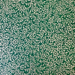 May include: A green background with a white floral pattern. The pattern is made up of small flowers and leaves.