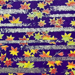 May include: Purple fabric with a repeating pattern of gold and multi-colored maple leaves. The fabric has a textured, brushed look.