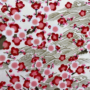 Peut inclure: Un tissu blanc avec un motif répétitif de fleurs rouges et roses avec des centres dorés. Le fond est brun clair avec un motif de vagues.