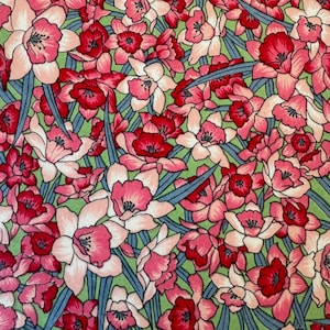 May include: A green fabric with a repeating pattern of pink and red flowers. The flowers are stylized and have a vintage look.