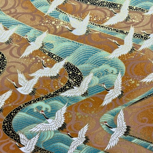 May include: A repeating pattern of white cranes flying over blue and gold waves. The background is a textured gold color with black accents.