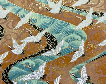 May include: A repeating pattern of white cranes flying over blue and gold waves. The background is a textured gold color with black accents.