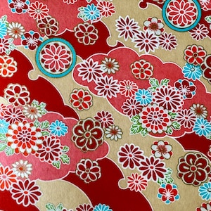 May include: Red and beige fabric with a repeating pattern of flowers and swirls. The flowers are in shades of red, pink, white, and blue. The swirls are in a gold color.
