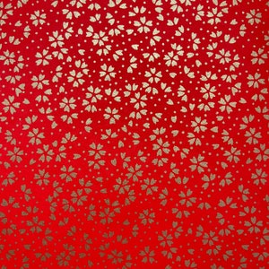 Può includere: Carta rossa con un motivo ripetitivo di forme di fiori dorati.