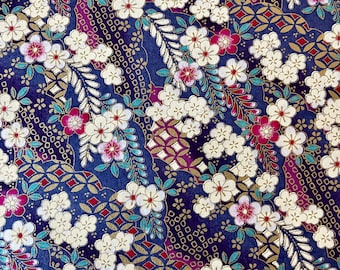 May include: A blue fabric with a repeating pattern of white flowers, pink flowers, and gold geometric shapes.