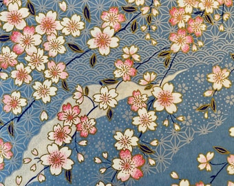 May include: A blue background with a repeating pattern of white and pink cherry blossoms. The blossoms are arranged in a flowing pattern with gold accents.